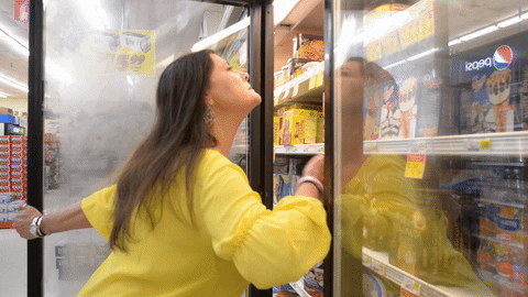 Eine Frau kühlt sich im Kühlschrank ab. Hitzewallungen